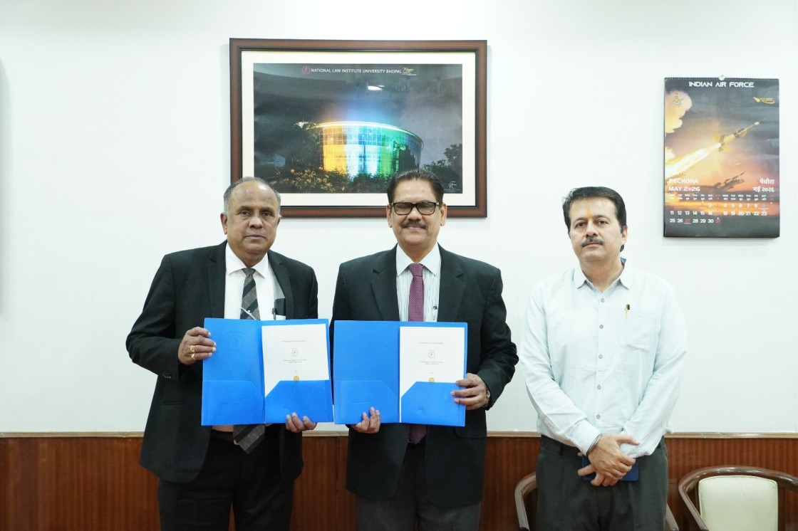 Three men in business attire pose in an office, two holding blue folders with documents.